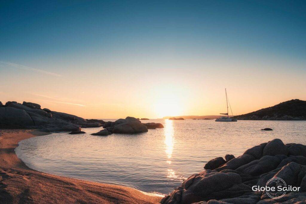 Foto eines bei Sonnenuntergang ankernden Bootes: Die Vorschriften für das Segeln und Yachtchartern in Italien  schützen die Natur und erhalten ein Traum-Segelrevier.