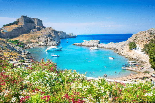 Geschützte Bucht auf Rhodos mit Strand, Badegästen und ankernden Booten im klaren Wasser