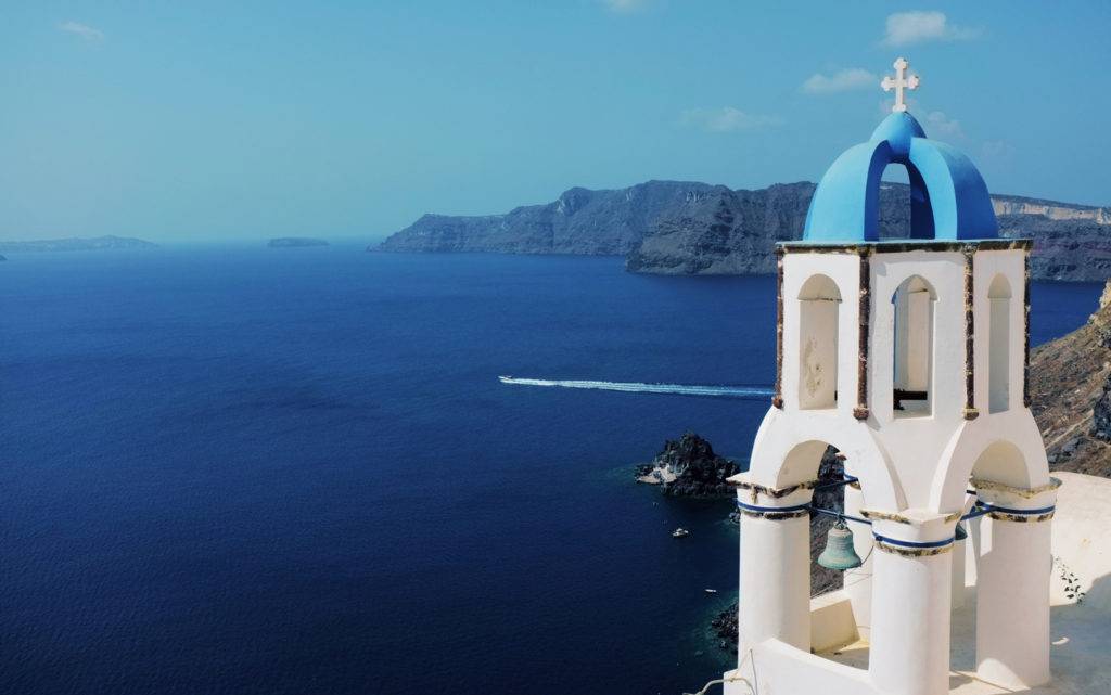 Blick auf Santorini mit typischer Kirche und blauem Meer – beliebtes Ziel für Segel- und Katamaranreisen