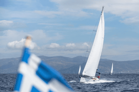 Segelboot mit griechischer Flagge auf offenem Meer – klassisches Segelerlebnis in Griechenland