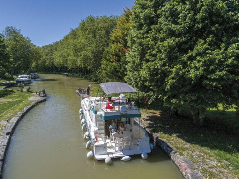 Ein luxeriöses Hausboot mit mehreren Etagen auf einem Fluss